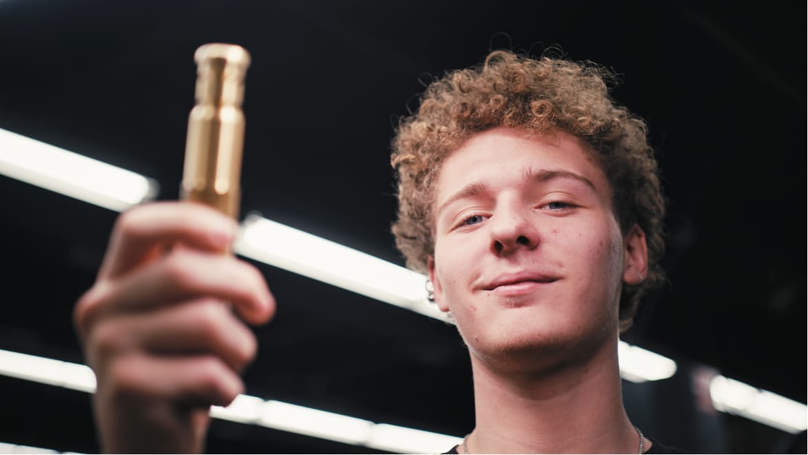 Student smiling holding metal part