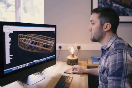 Image shows a boat designer operating a computer