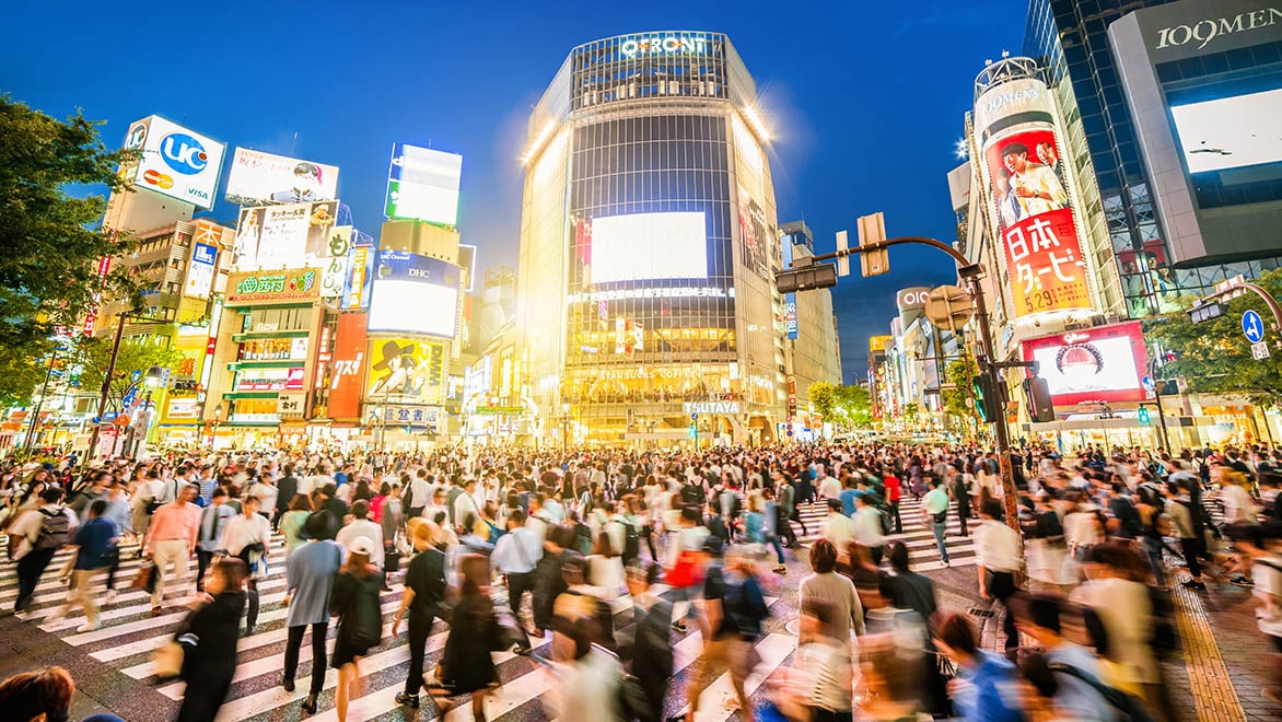 歩行者で溢れる東京の交差点の写真。