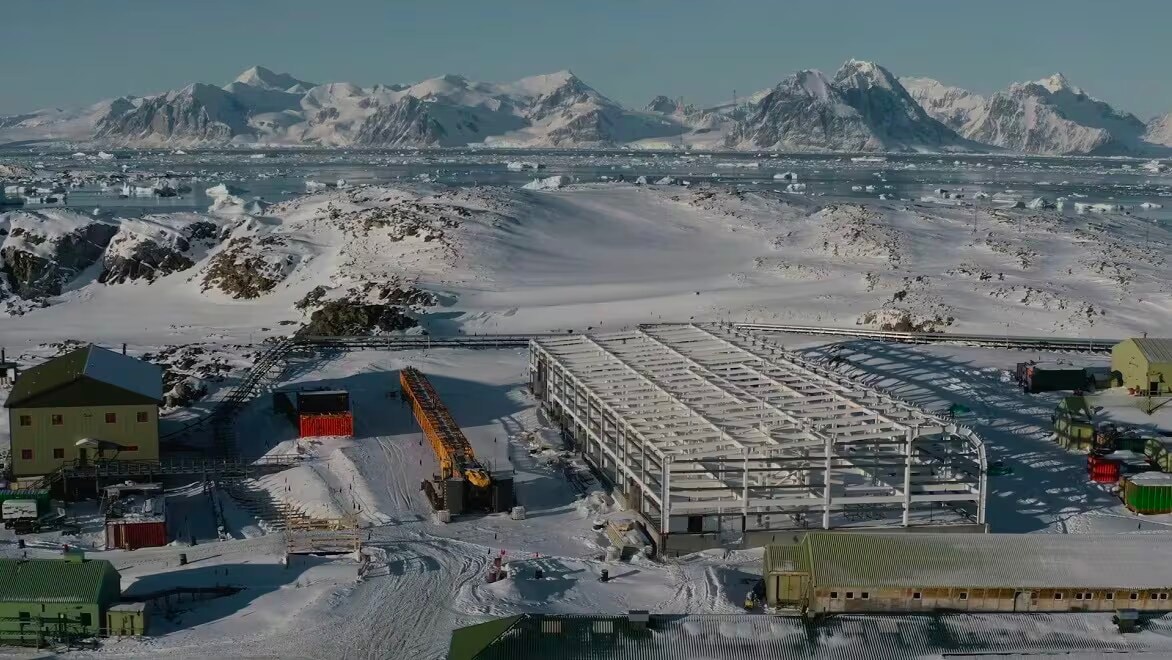 Construction happening in Antartica, surrounded by small buildings