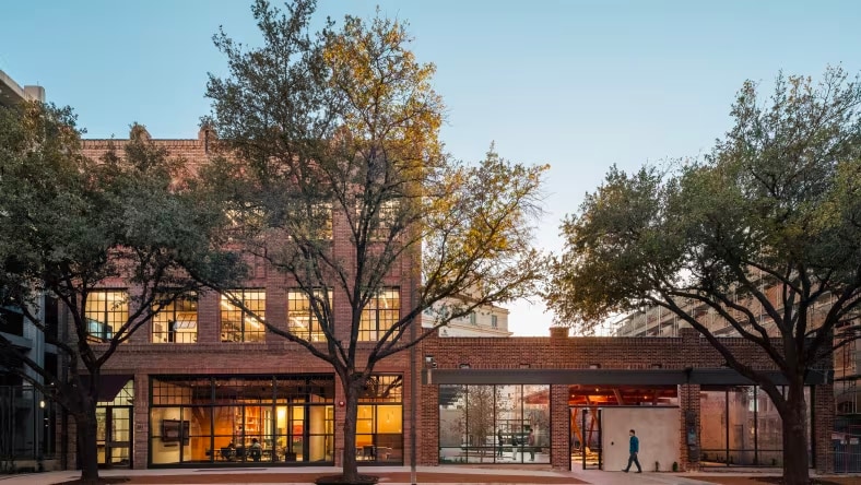 Modern brick and glass building with trees on street