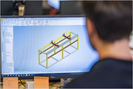 Young man using Autodesk software to prototype rectangular structure
