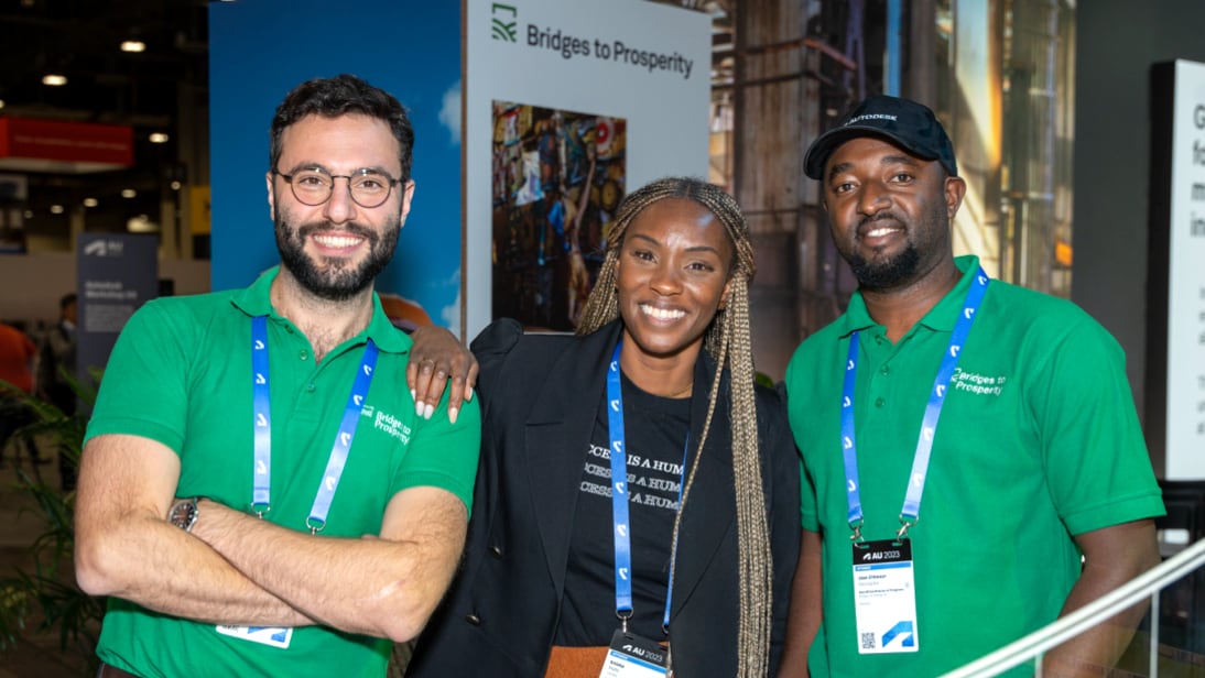 Group photo of three B2P employees standing and smiling at the camera at the B2P exhibit in the AU 2023 Exhibit Hall (left to right): Nicola Turrini, Global Corporate Partnerships Manager; Eniola Mafe-Abaga, Global Advocacy & Partnerships Director; and Jean D'Amour Rwunguko, Programs Director, East Africa.