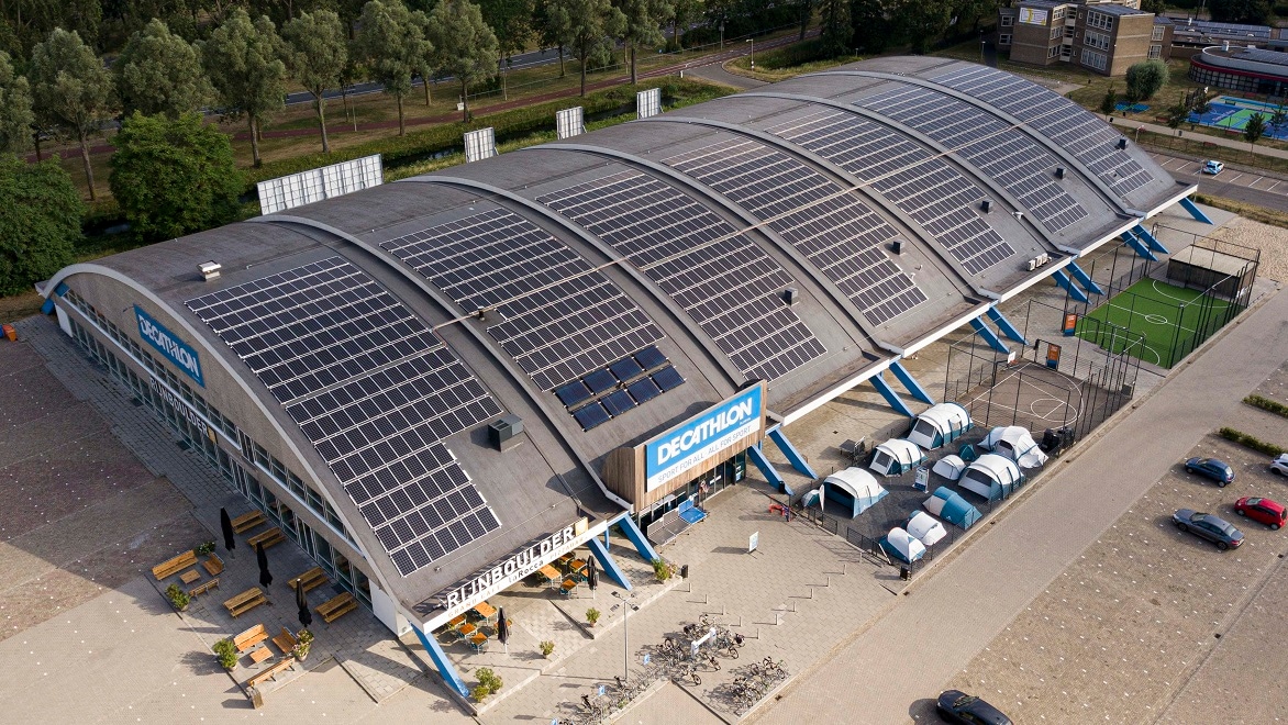 Een Decathlon-winkel met zonnepanelen die op het gebogen dak zijn geïnstalleerd. 