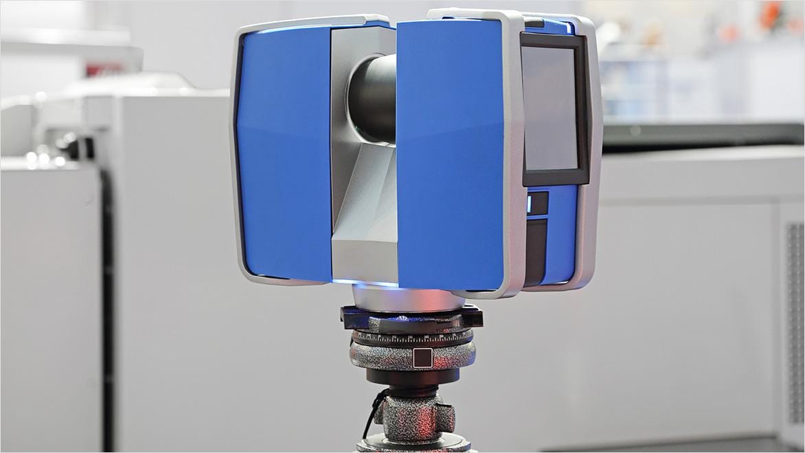 A 3D scanner is on a tripod inside an office.