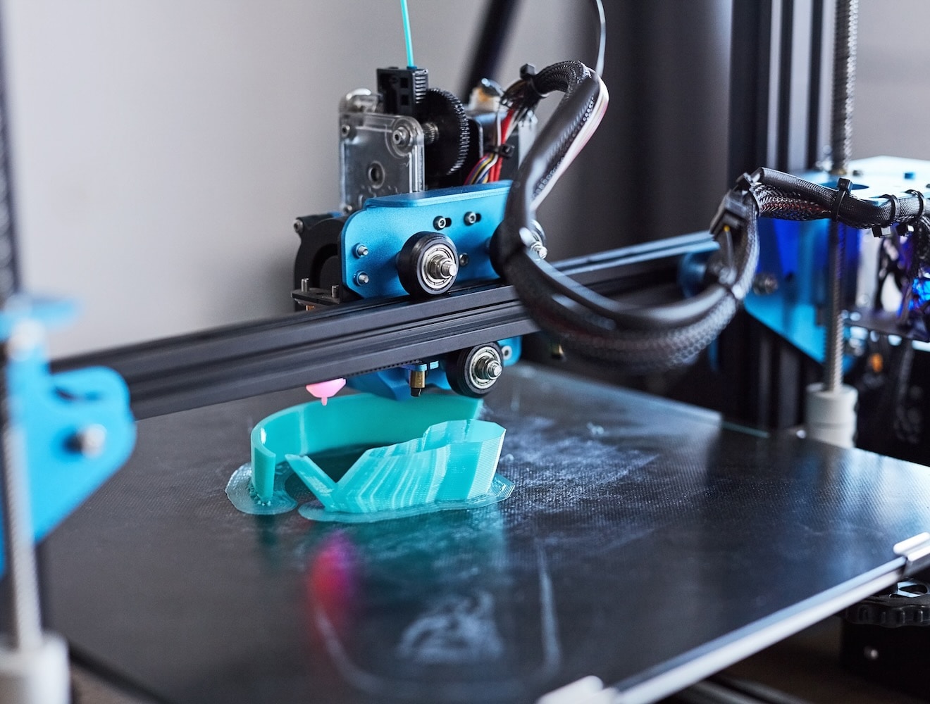 1803644721 A 3D printer creates a blue plastic part.