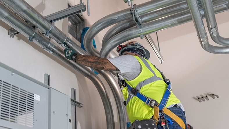 An engineer adjusts a building ventilation system.