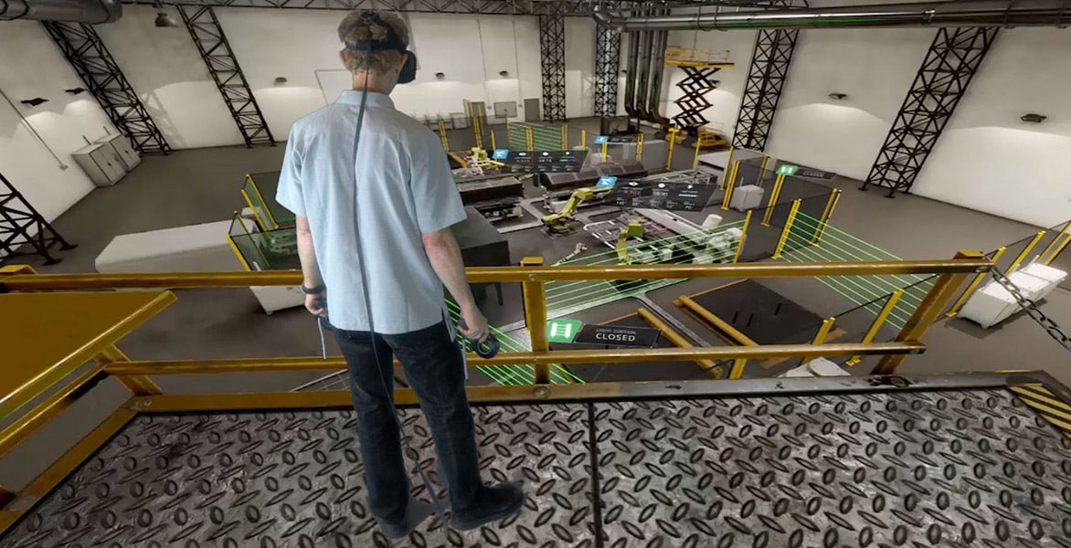 A man views a factory floor using VR goggles.
