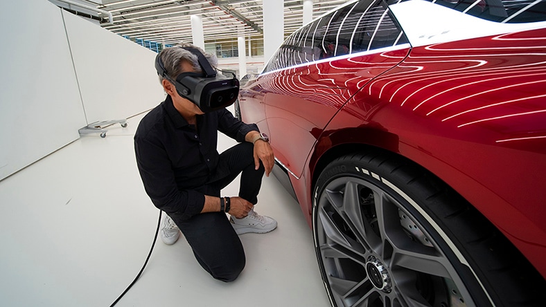 a man views a car with VR goggles.