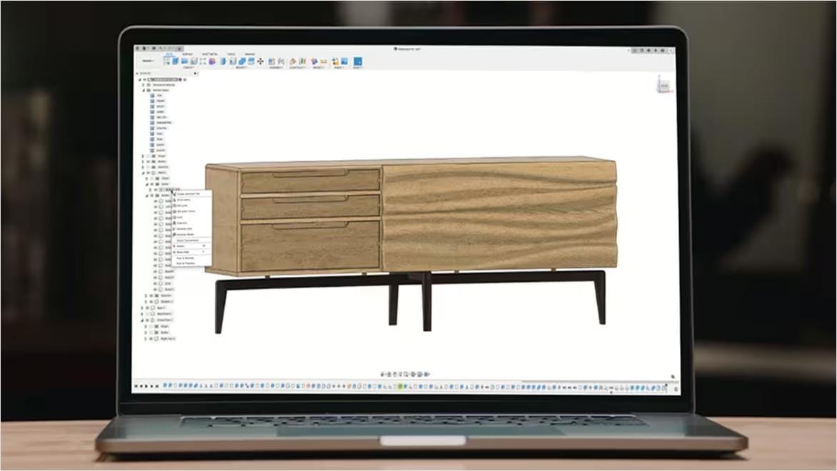 A laptop computer showing an Autodesk Fusion window with 3D rendering of a sideboard design.