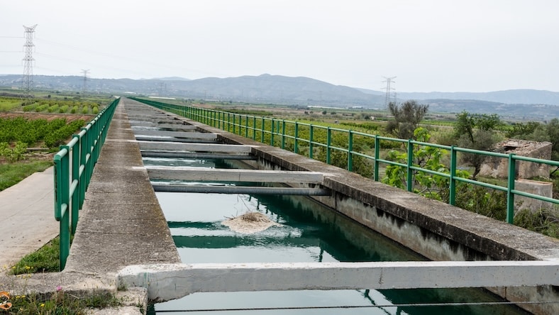 A concrete water channel is filled to capacity.