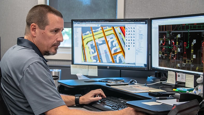 A man works on an HVAC system design, shown on his computer screen.
