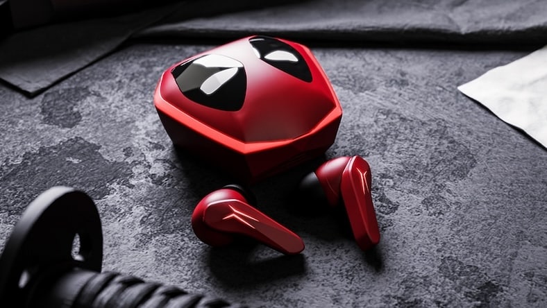 rgb Red earbuds next to a red earbud case designed to look like the mask of the Marvel character, Deadpool.