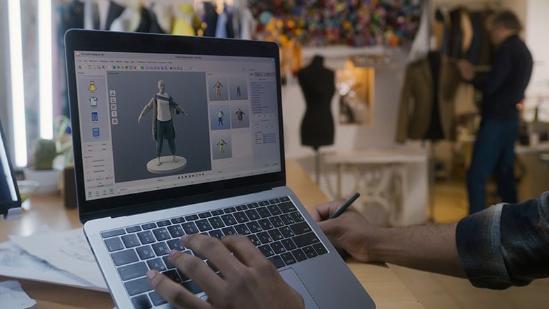 1455816499 A designer creates 3D clothes on a laptop.
