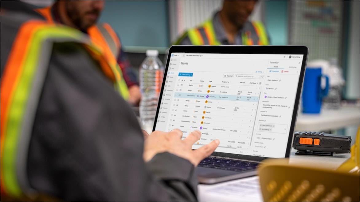  A construction worker works on a laptop computer during a meeting.