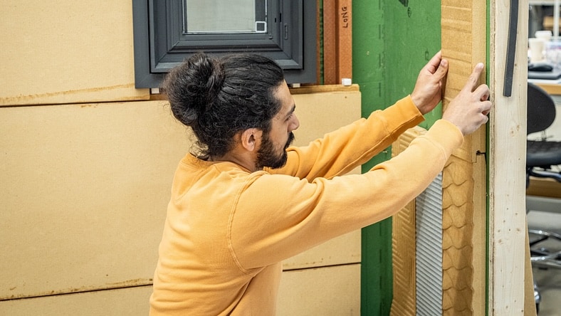 A worker installs high-efficiency insulation.