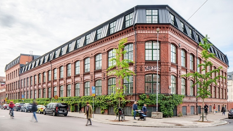 Image of a refurbished factory building and people walking in the street.