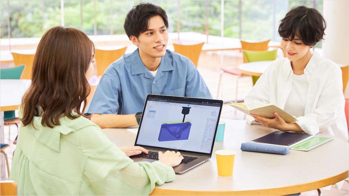 Fusion students sit at a table with laptops at the Nihon Kogakuin College of Hachioji in Tokyo, Japan.