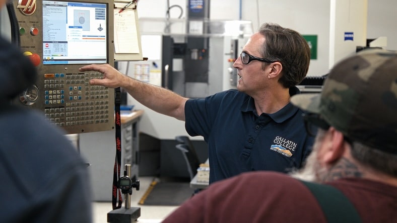 Gallatin College educator programming CNC machine.