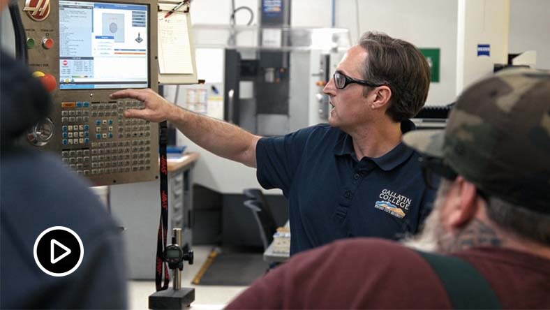 Gallatin College educator programming CNC machine.