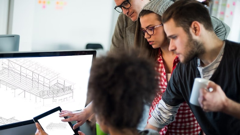 Architects and their clients review a steel structure diagram on a tablet.