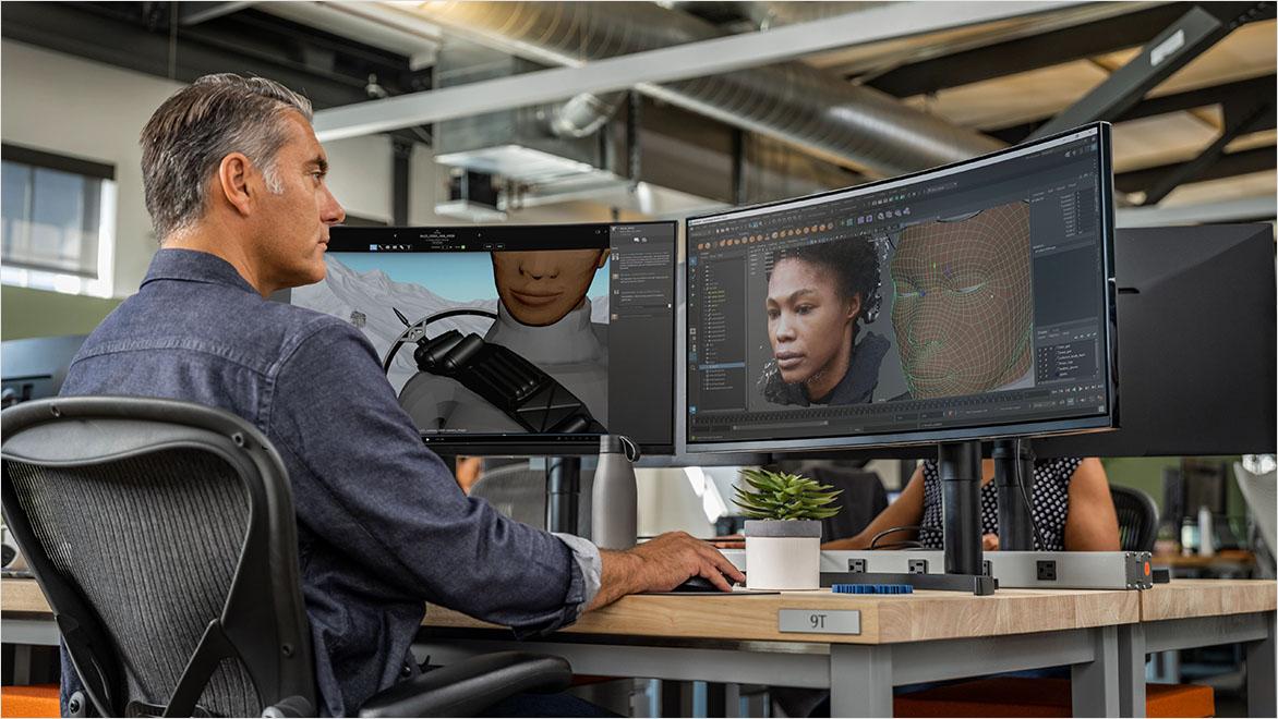 A man works on a game character animation on a computer screen.