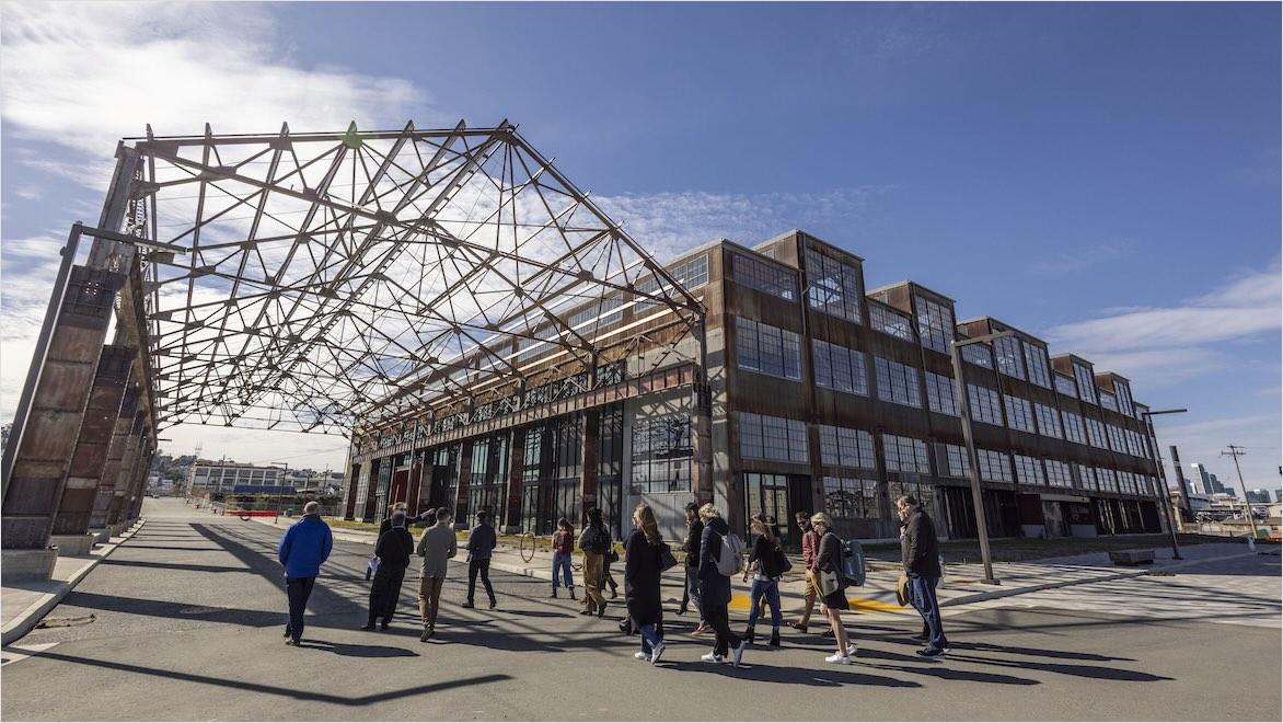 People walk toward the renovated Building 12 on Pier 70 in San Francisco.