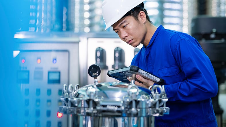 A worker inspects a water filter system in a treatment plant.