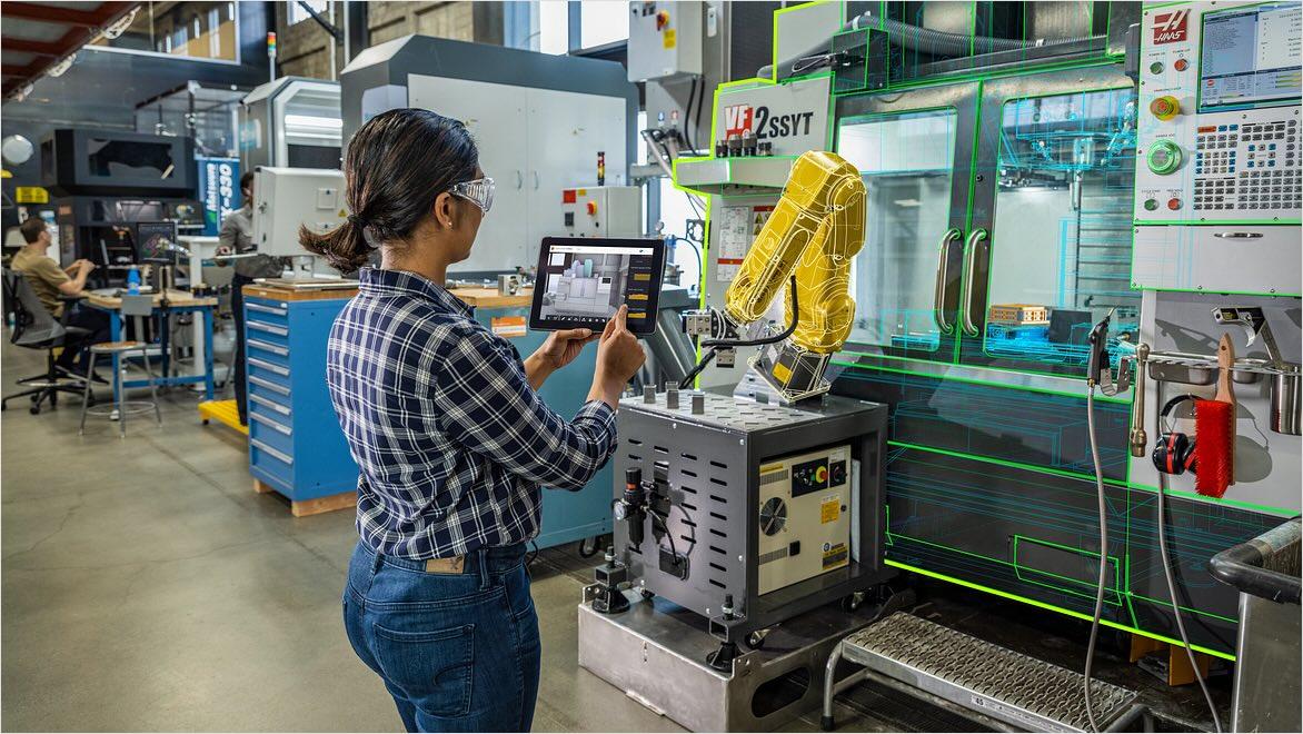 A woman works on a tablet while standing by a CNC machine with an overlay implying digital integration.