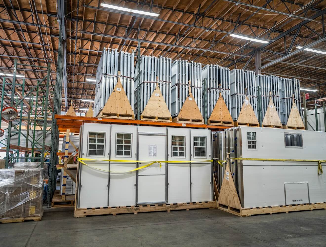 Doors, walls, and other housing modules await assembly in a factory.