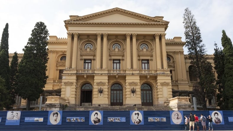 An image shows a small crowd gathered outside of the Museu do Ipiranga in Brazil.