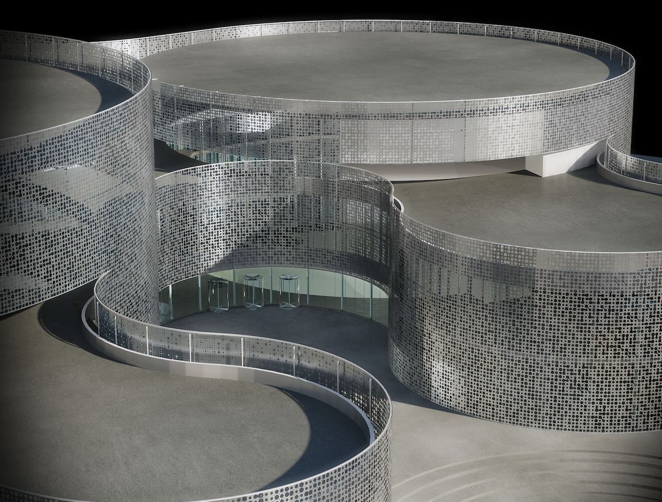 A rendering shows a modern building with curved, perforated metal facades and glass doors.