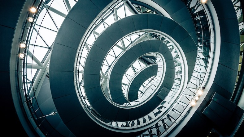 An interior photograph of London’s City Hall illustrates circular steel architectural elements.