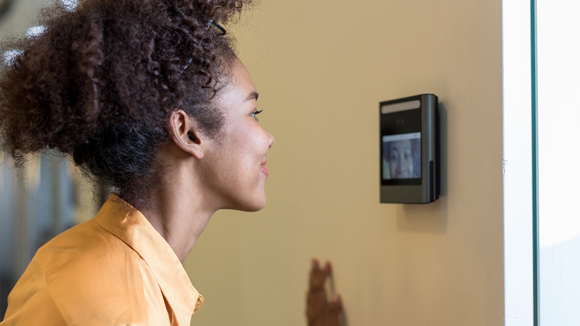 A woman stands in front of a facial recognition station.