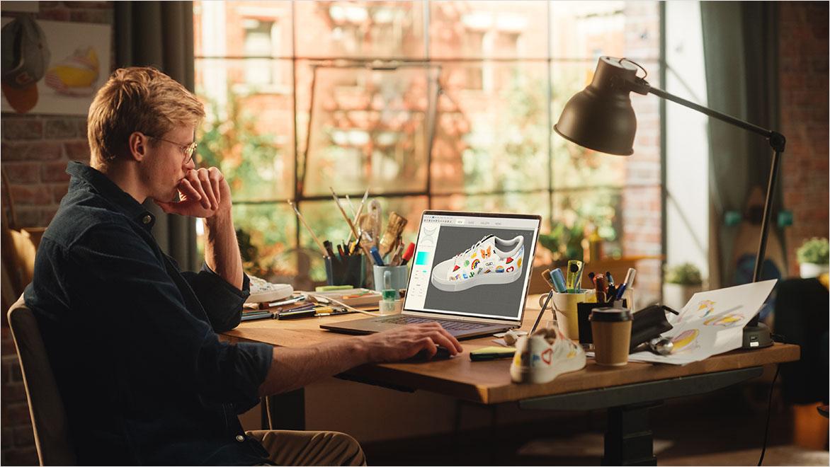 A man looks at a computer screen showing a custom sneaker design.