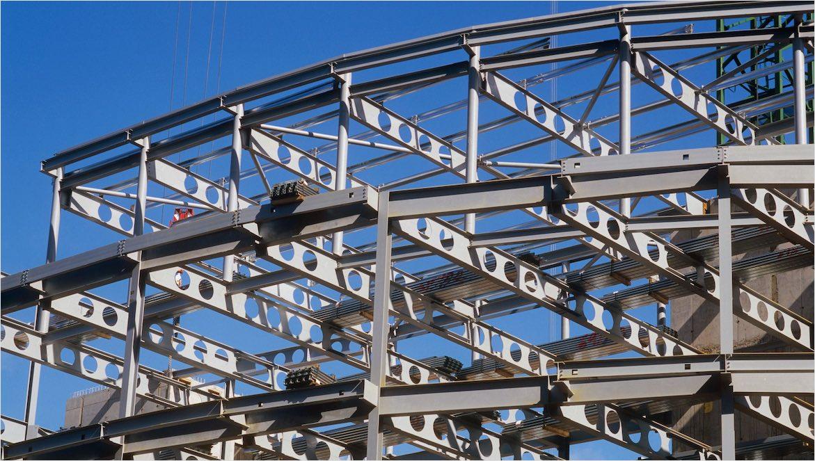 A building’s steel construction system is visible during early stages of construction.
