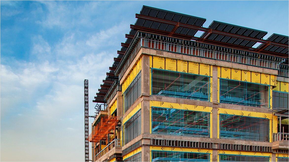 A building under construction with overlays showing design schematics