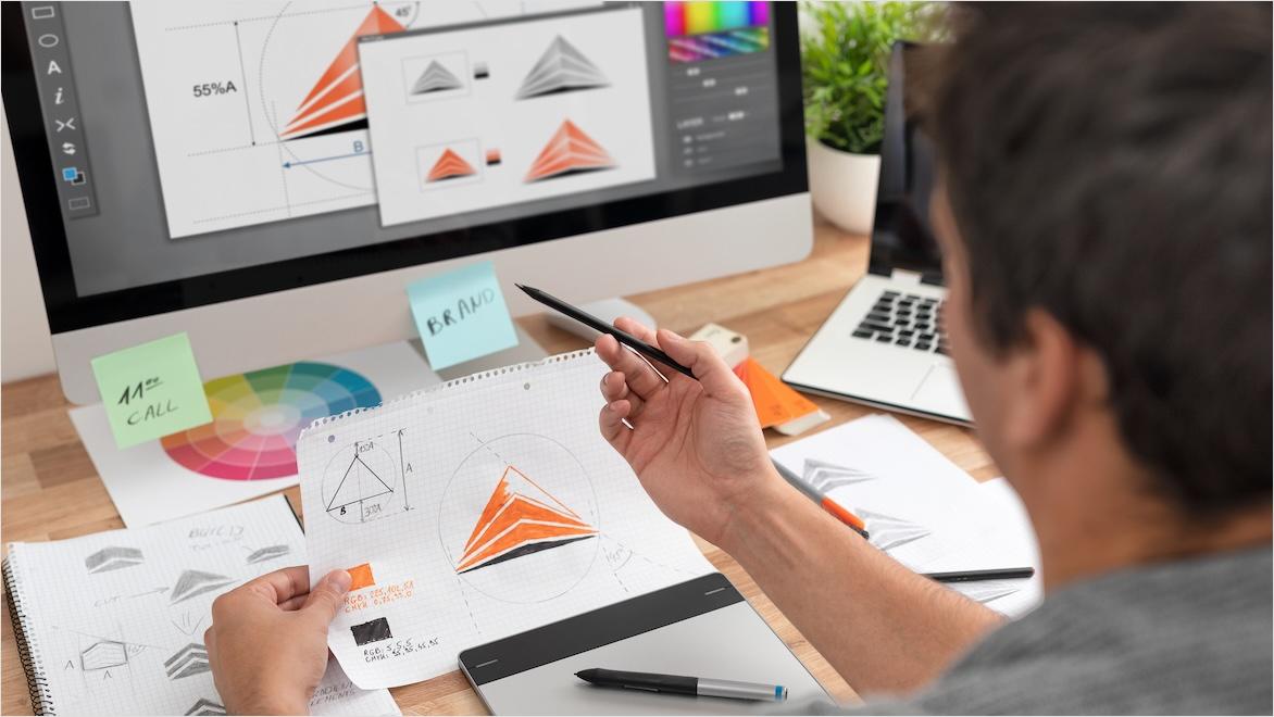 A graphic designer uses software to turn a sketch into a logo.