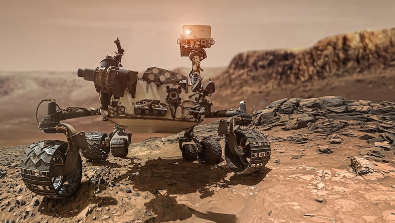 A computer-generate image of a NASA rover explores terrain.