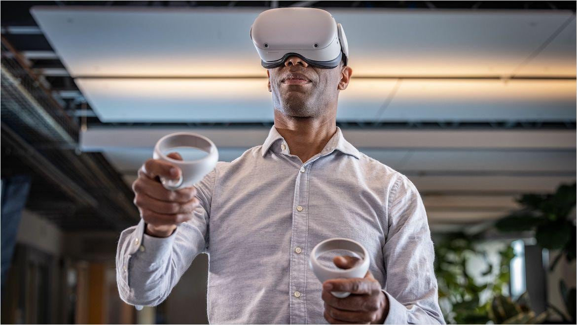 Man wearing virtual reality headset and using hand remotes