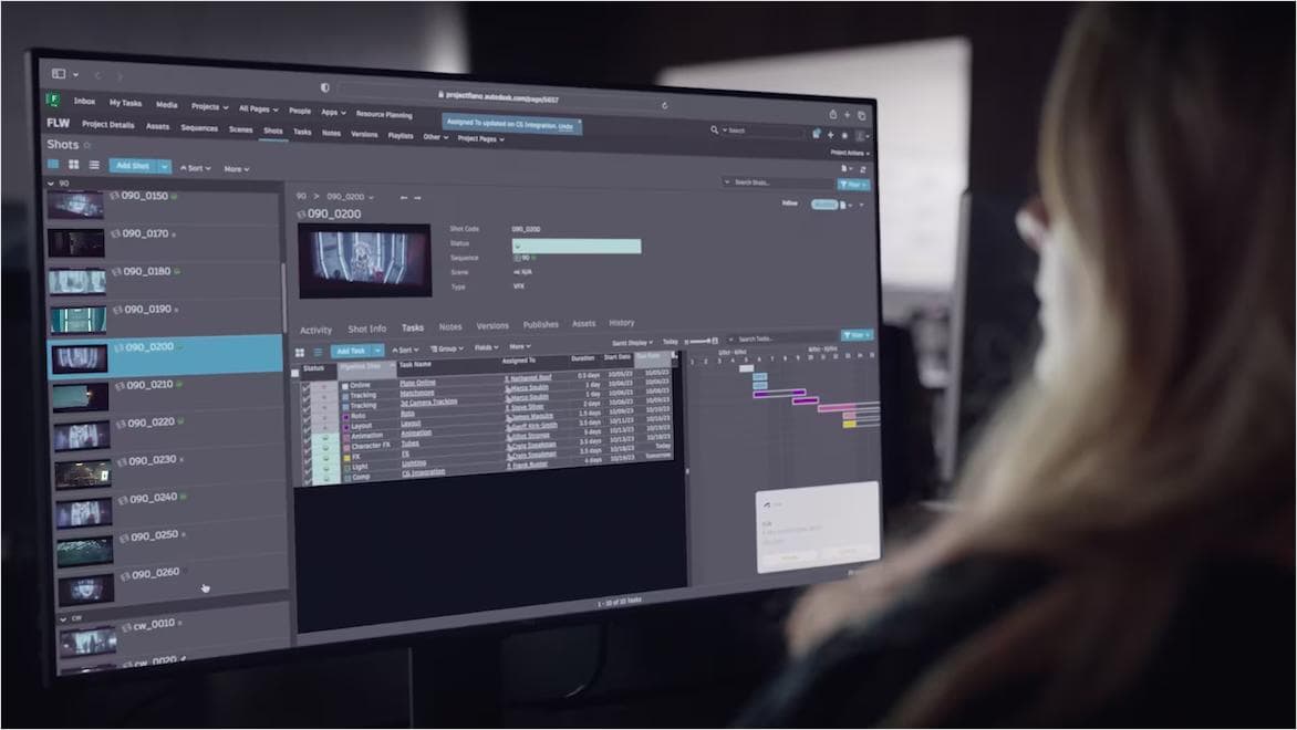 A young woman faces a computer monitor displaying a screen from Flow Production software.