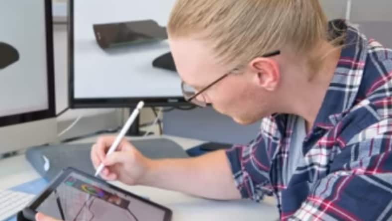 Young male engineering student using stylus to work on a 3d model on a tablet