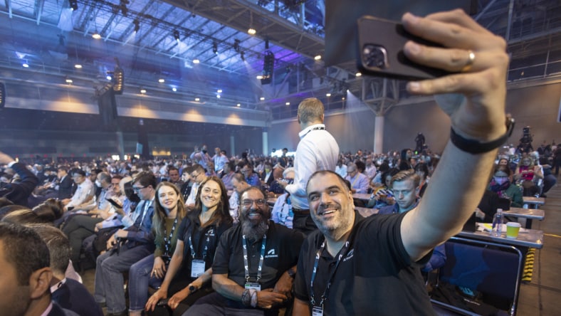 Image of people sitting in an auditorium posing for a selfie