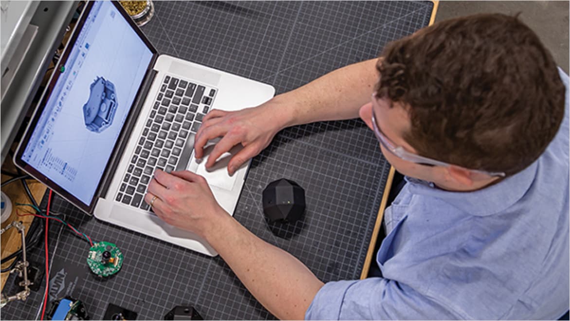 Overhead view of man designing on laptop computer