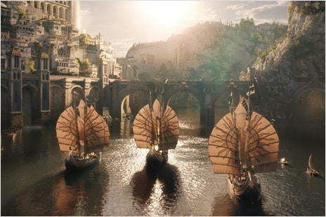 Shot from "The Lord of the Rings: The Rings of Power" showing three boats sailing through a fantasy landscape.