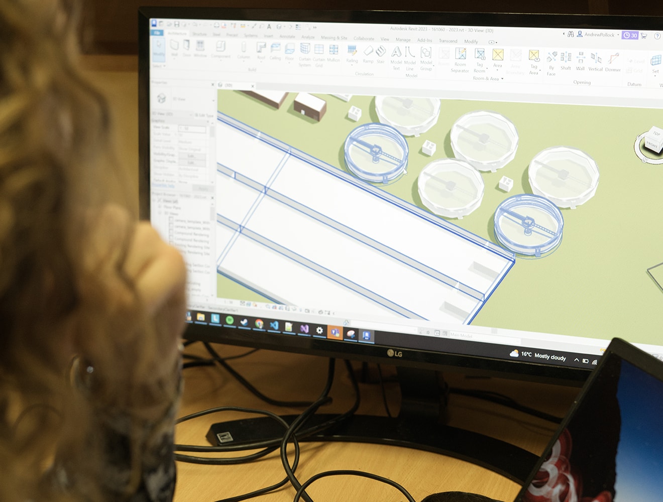 a woman looking at a treatment plant model in design software