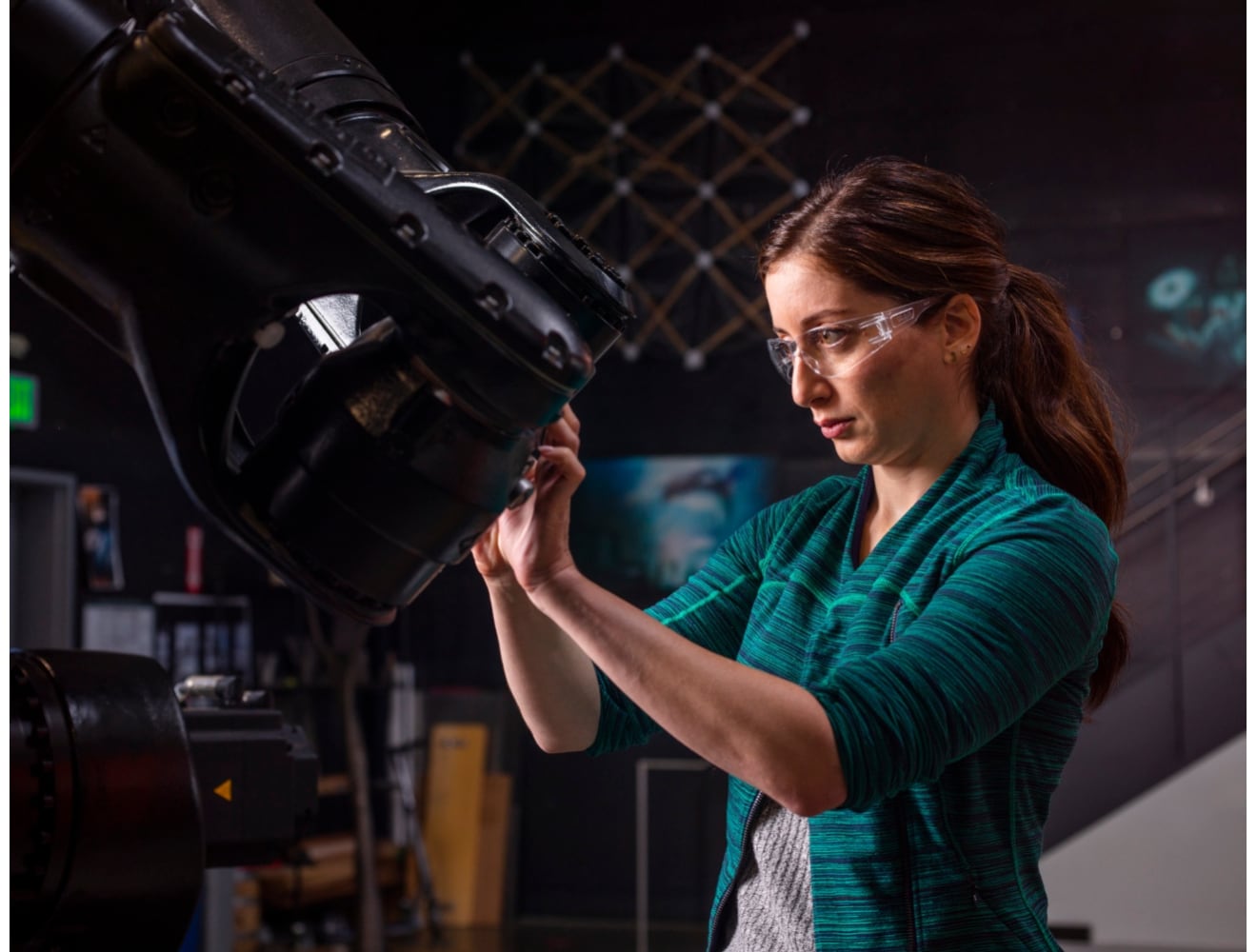 student wearing protective glasses works on a machine