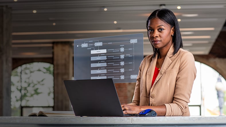 Engineering manager working on laptop with supply chain collaboration workflow displaying