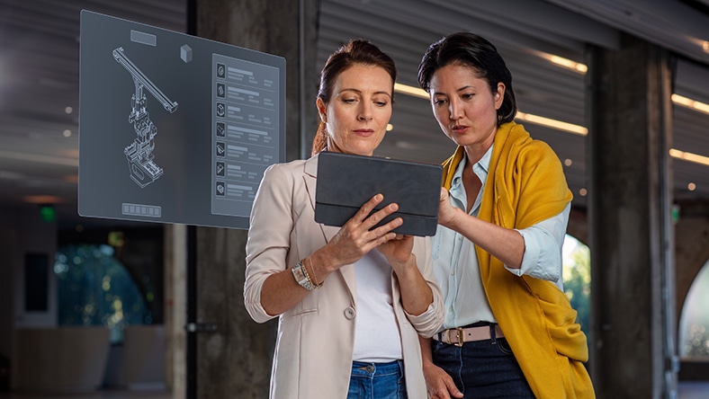 Two women looking at tablet displaying bill of materials