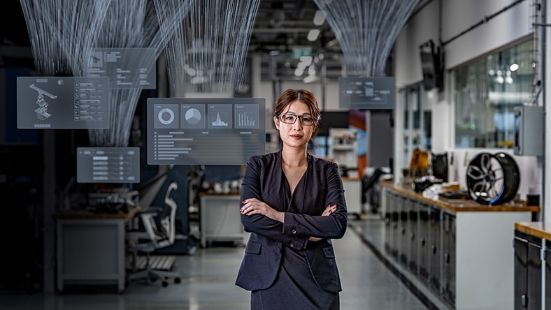 Engineering manager with multiple displays behind her showing PLM workflows